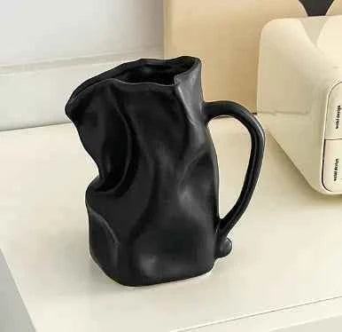 wrinkled texture ceramic vase in black showcased on a modern table, unique sculptural design for contemporary decor.