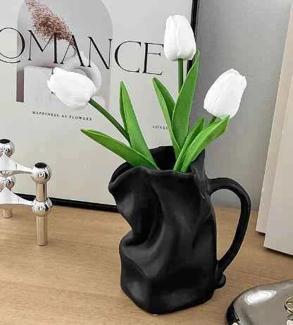 Wrinkled texture ceramic vase with white tulips, modern home decor accent on a wooden table.