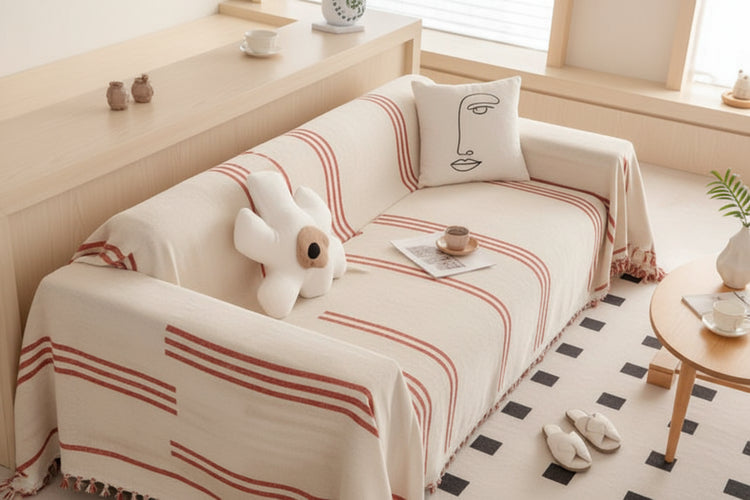 Machine washable chenille throw blanket with tassels draped over a cozy couch, enhancing living room aesthetics.