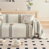 machine washable chenille throw blanket draped over a sofa with a decorative pillow in a modern living room setting.
