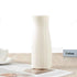 Nordic durable plastic flower vase in white on a wooden table for modern home accent decoration.